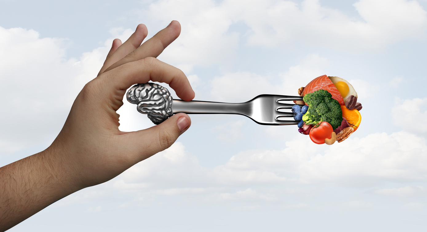 hand holding a fork with a brain on it, collecting healthy vegetables and meats