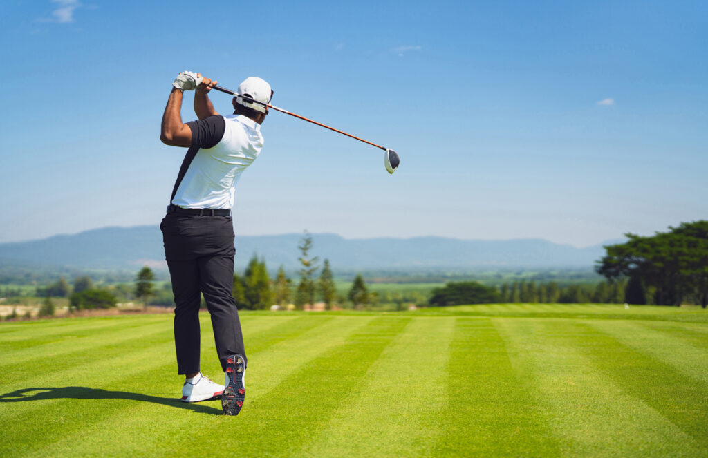 Asian man golfing on the course. In summer